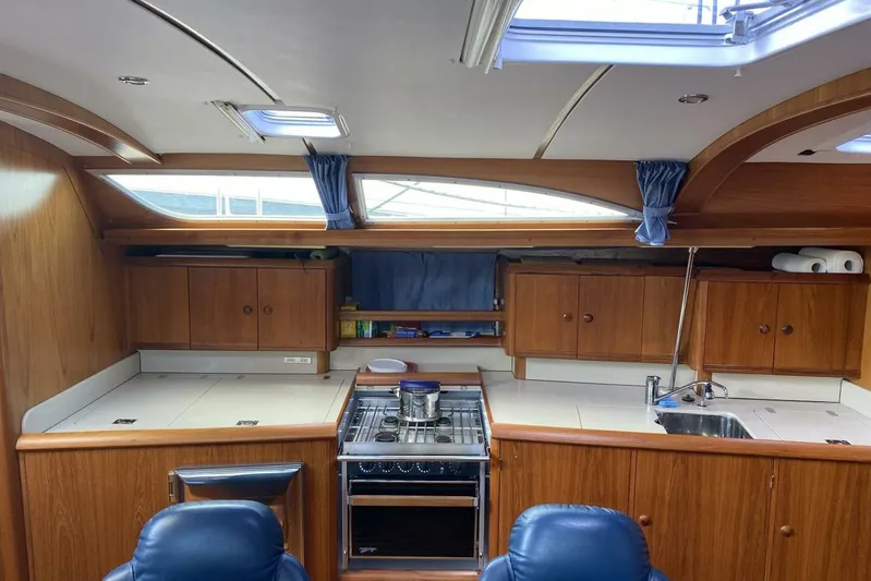 Free Spirits Yacht Photos Pics Interior of 2000 Jeanneau Sun Odyssey 45.2 yacht with wooden cabinetry and modern kitchen amenities.