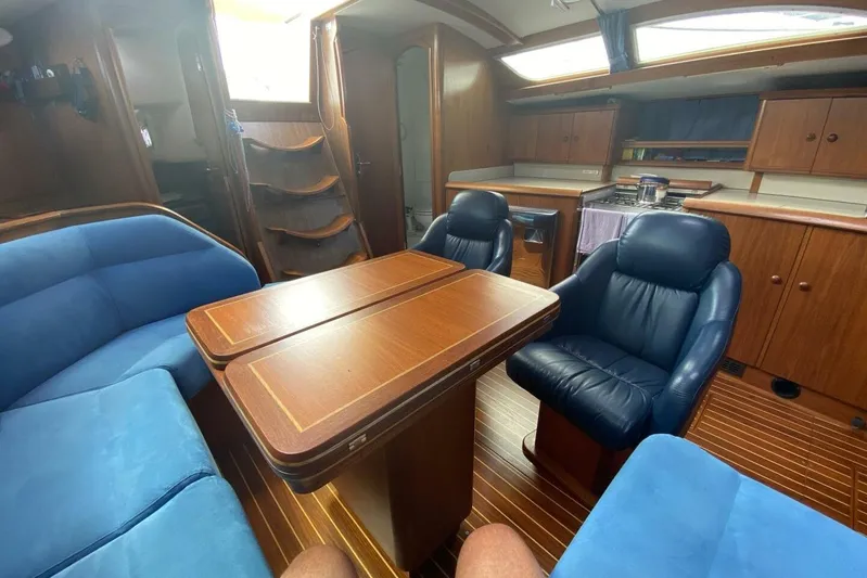 Free Spirits Yacht Photos Pics Interior of 2000 Jeanneau Sun Odyssey 45.2 yacht with blue seating and wooden finishes.