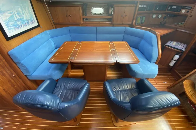 Free Spirits Yacht Photos Pics Luxurious interior of 2000 Jeanneau Sun Odyssey 45.2 yacht with blue seating and wooden table.
