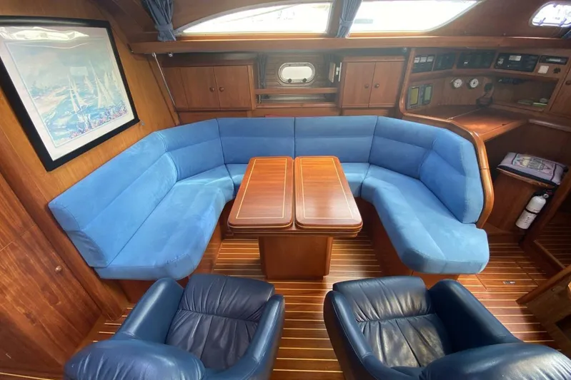 Free Spirits Yacht Photos Pics Interior of 2000 Jeanneau Sun Odyssey 45.2 yacht with blue seating and wooden accents.