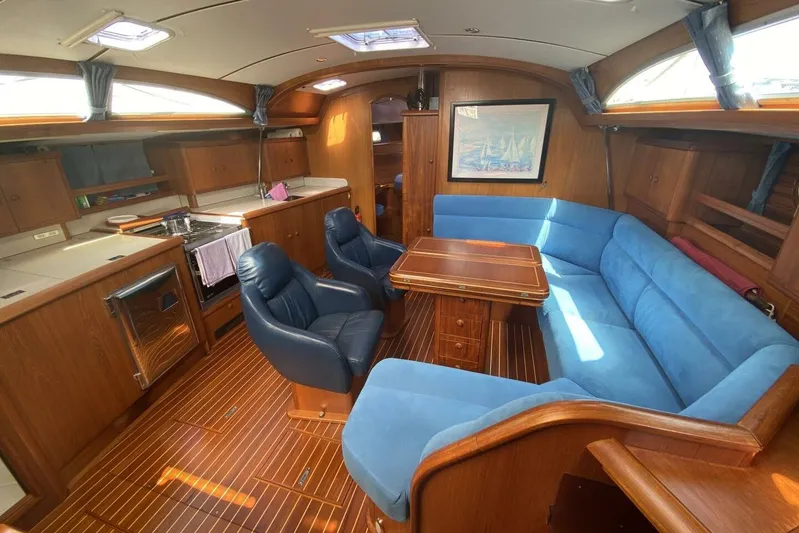 Free Spirits Yacht Photos Pics Luxurious interior of 2000 Jeanneau Sun Odyssey 45.2 yacht with blue seating and wooden finishes.