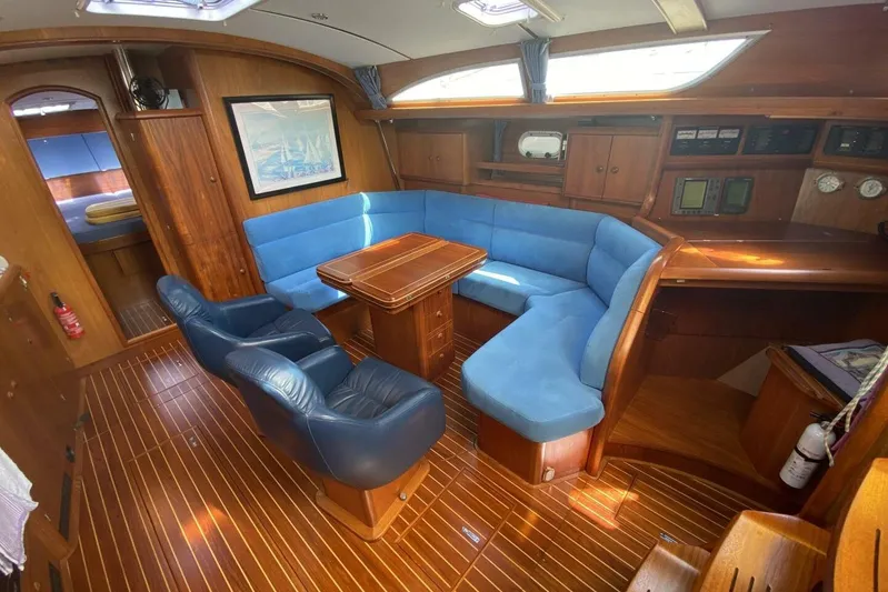 Free Spirits Yacht Photos Pics Interior of 2000 Jeanneau Sun Odyssey 45.2 yacht with blue seating and wooden finishes.