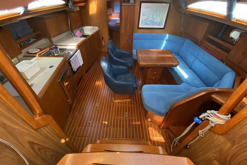 Free Spirits Yacht Photos Pics Interior of 2000 Jeanneau Sun Odyssey 45.2 yacht with blue seating and wooden finishes.