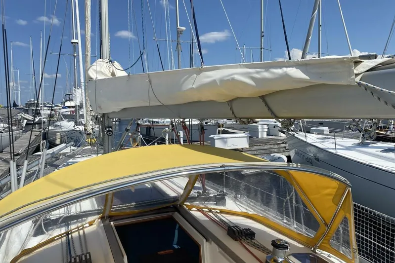 Free Spirits Yacht Photos Pics Jeanneau Sun Odyssey 45.2 sailboat docked at marina, yellow canopy, clear sky.