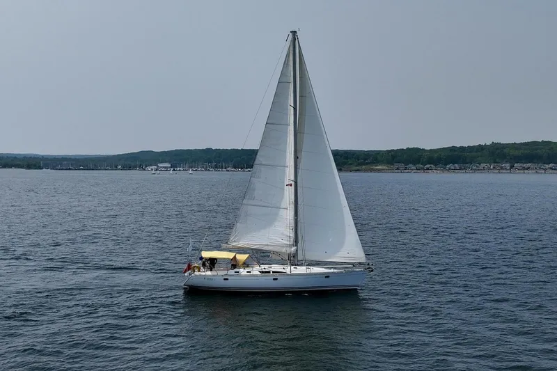 Free Spirits Yacht Photos Pics Jeanneau Sun Odyssey 45.2 sailboat from 2000 sailing on a calm lake.