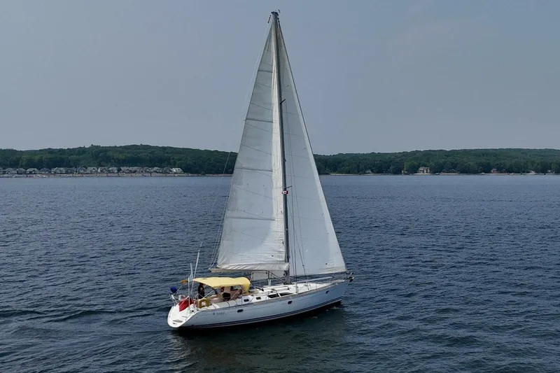 Free Spirits Yacht Photos Pics Sailing yacht Jeanneau Sun Odyssey 45.2, 2000 model, cruising on a serene lake.