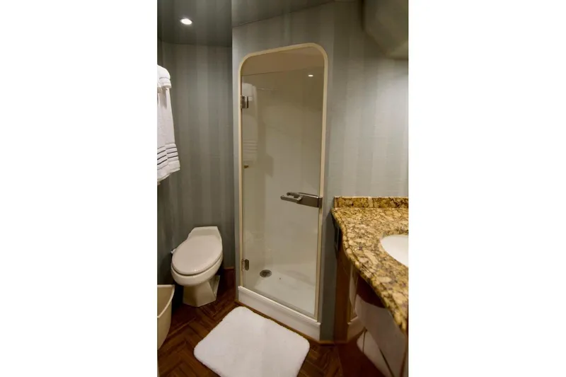 Serenity Now Yacht Photos Pics Bathroom interior of 2014 Viking 66 Convertible yacht with shower, toilet, and granite countertop.