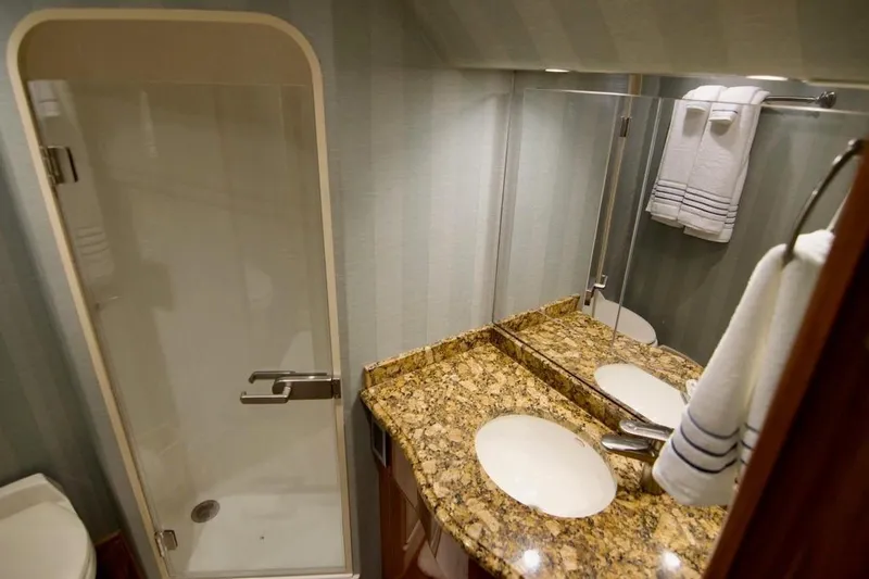 Serenity Now Yacht Photos Pics Luxurious bathroom in 2014 Viking 66 Convertible yacht with granite countertop and shower.