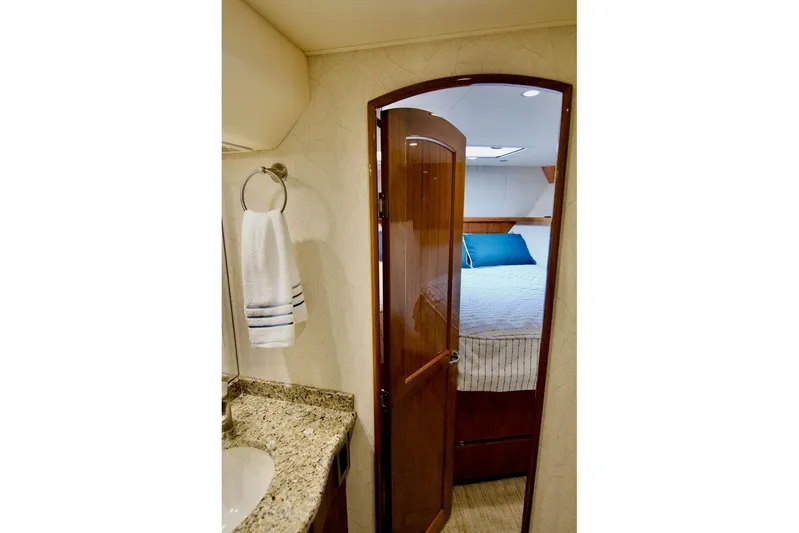 Serenity Now Yacht Photos Pics Luxurious interior of 2014 Viking 66 Convertible yacht, featuring a cozy bedroom and elegant bathroom.