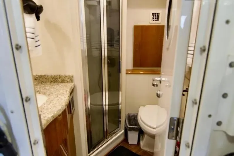 Serenity Now Yacht Photos Pics 2014 Viking 66 Convertible yacht bathroom with shower, toilet, and granite countertop.