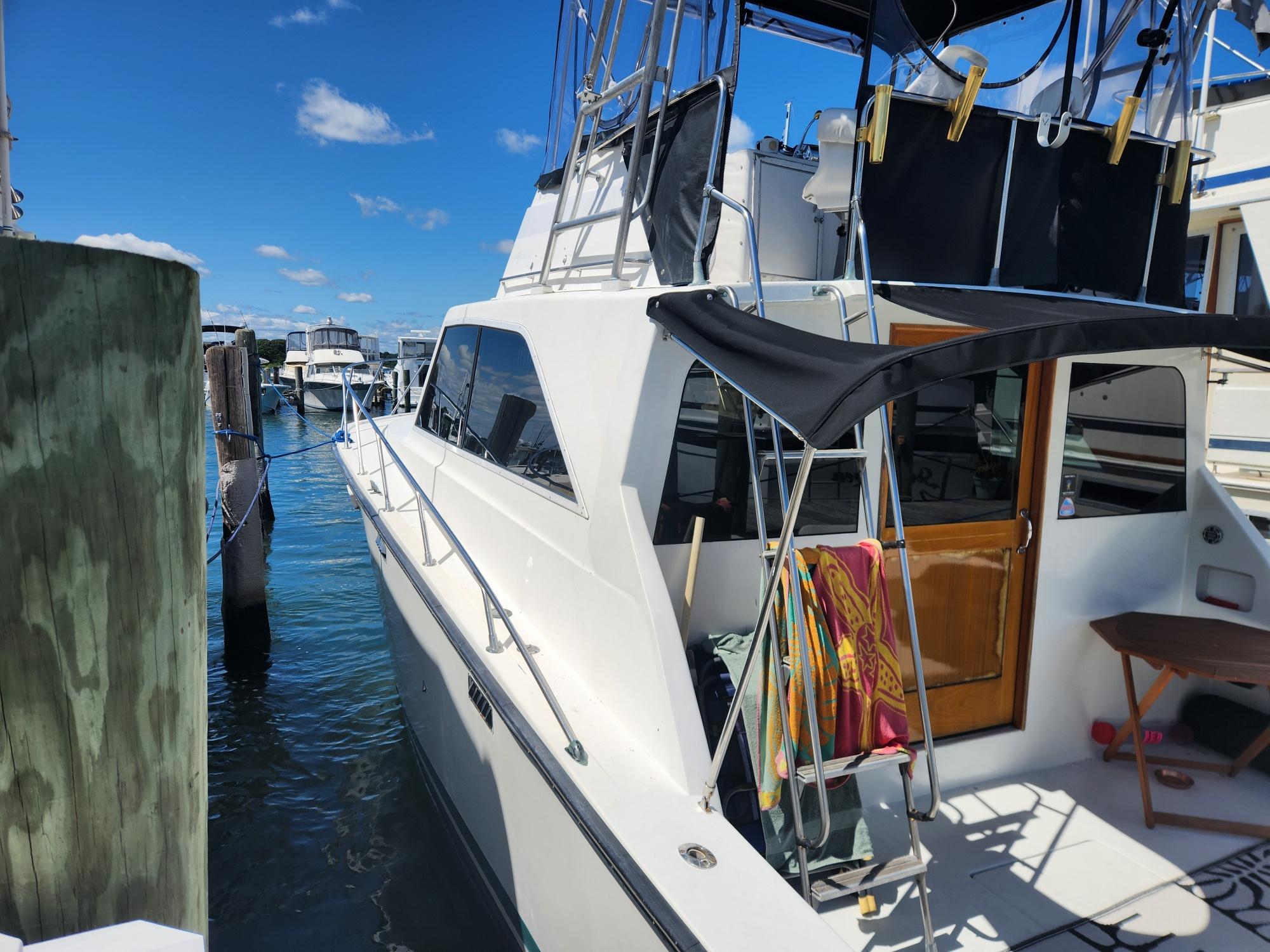 1977 Pacemaker 40 Sportfisherman docked, featuring sleek design and spacious deck.