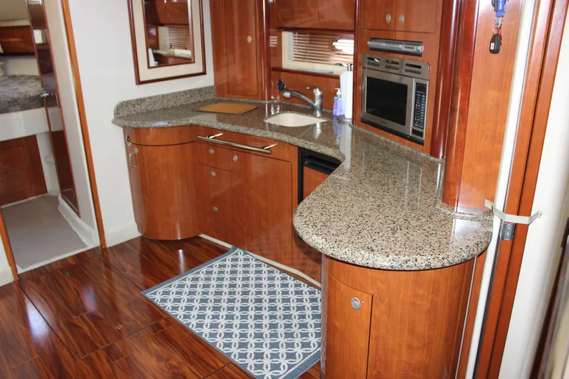  Yacht Photos Pics Luxurious kitchen interior of 2005 Sea Ray 420 Sundancer yacht with wood cabinetry and granite countertops.