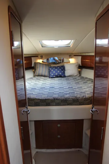  Yacht Photos Pics 2005 Sea Ray 420 Sundancer cabin with bed, pillows, and wooden cabinetry.