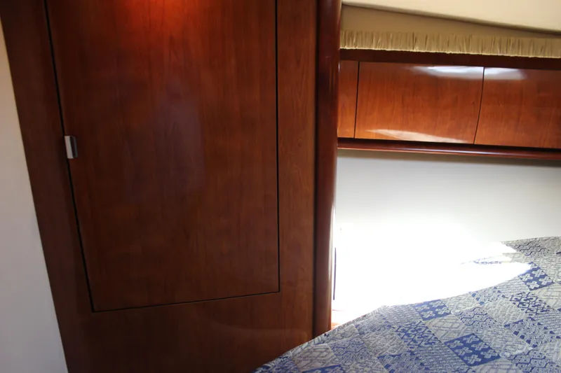  Yacht Photos Pics Interior of 2005 Sea Ray 420 Sundancer with wooden cabinetry and patterned bedding.