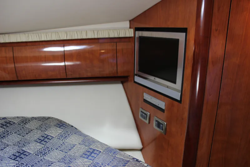  Yacht Photos Pics 2005 Sea Ray 420 Sundancer cabin with TV, wood paneling, and patterned bedding.