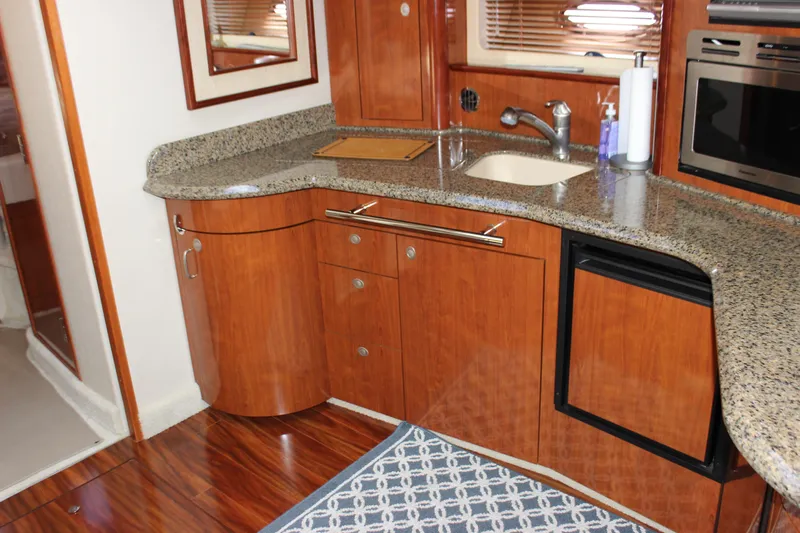  Yacht Photos Pics 2005 Sea Ray 420 Sundancer kitchen with wood cabinetry, granite countertops, and modern appliances.