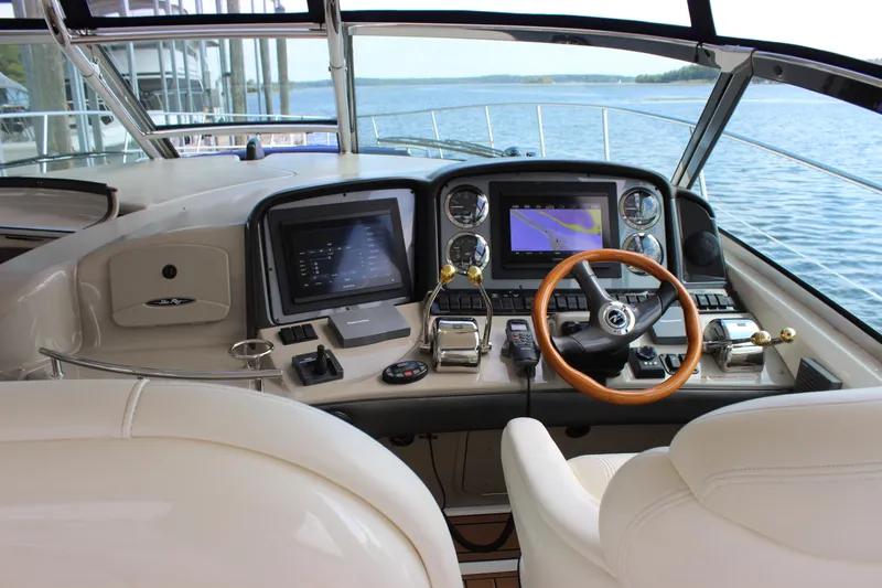  Yacht Photos Pics Helm of 2005 Sea Ray 420 Sundancer with navigation screens and wooden steering wheel.