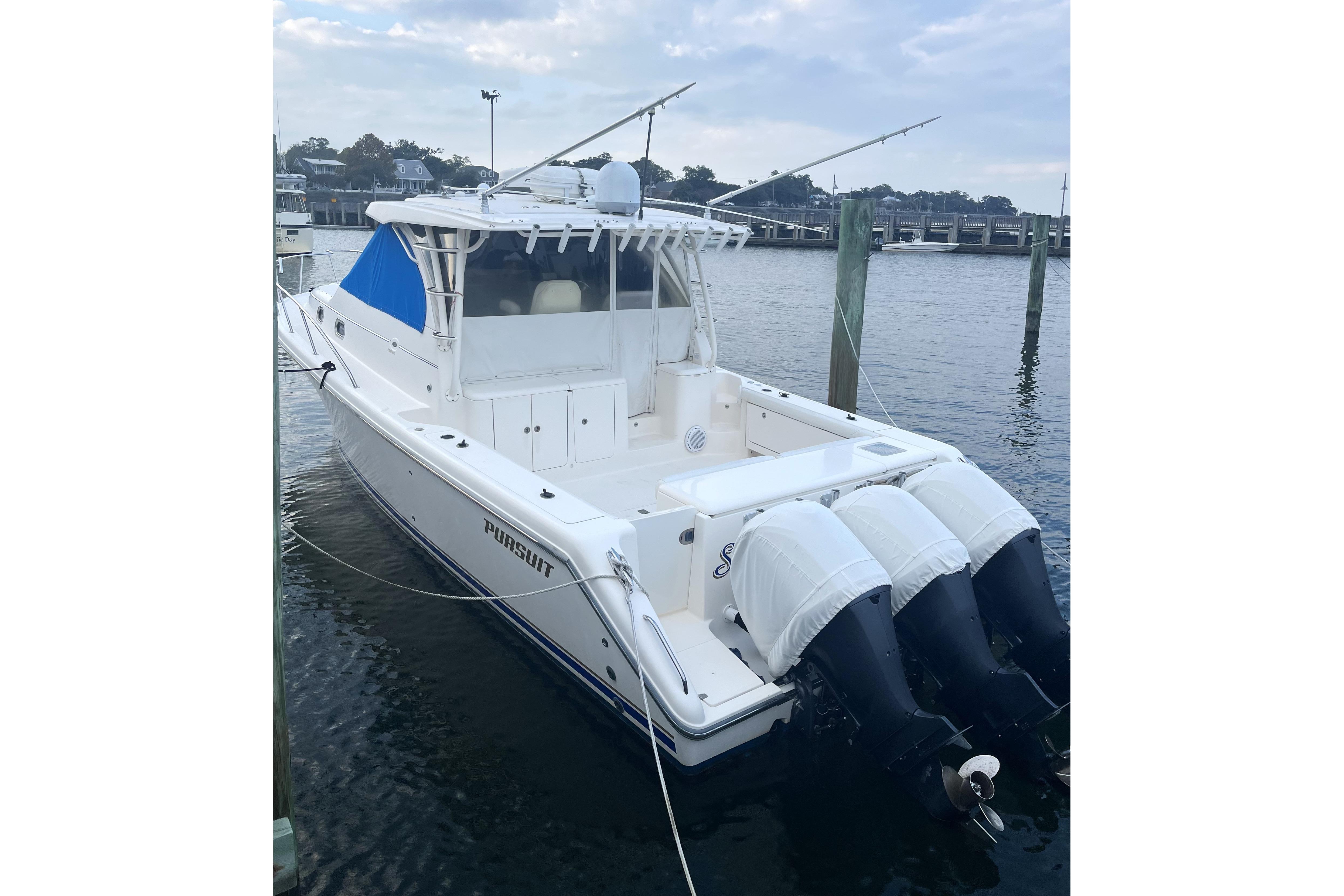 2013 Pursuit OS 385 Offshore boat docked with triple outboard engines.