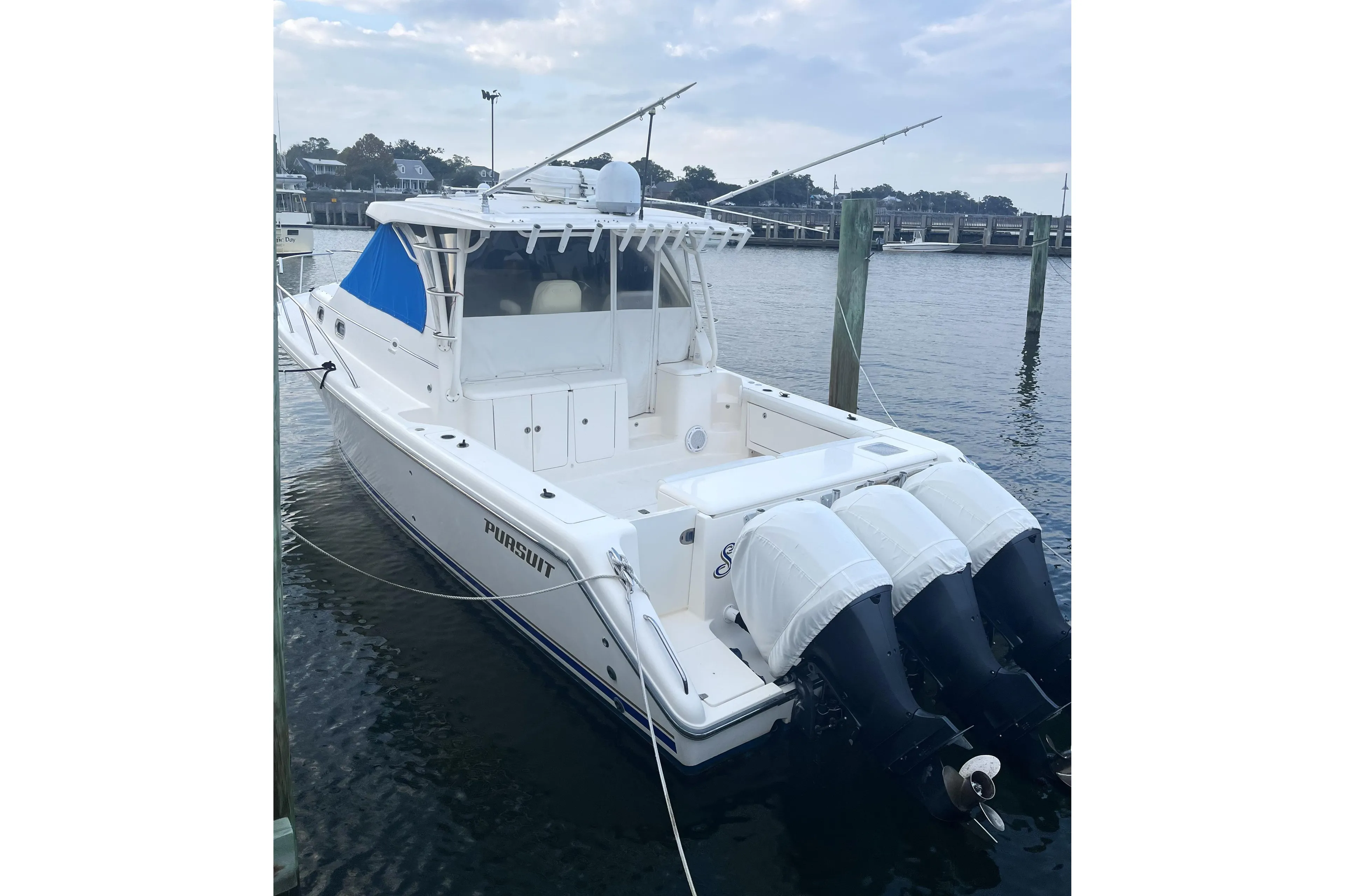 2013 Pursuit OS 385 Offshore boat docked with triple outboard engines.