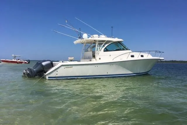 2013 Pursuit OS 385 Offshore boat on calm water under clear blue sky.