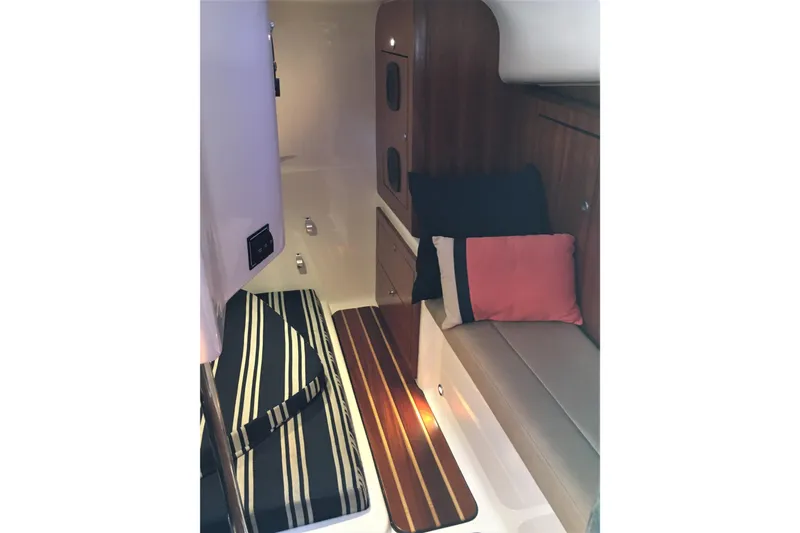  Yacht Photos Pics 2013 Pursuit OS 385 Offshore cabin interior with cushions and wood accents.