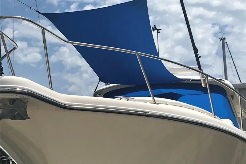  Yacht Photos Pics 2013 Pursuit OS 385 Offshore boat with blue sunshade under a cloudy sky.