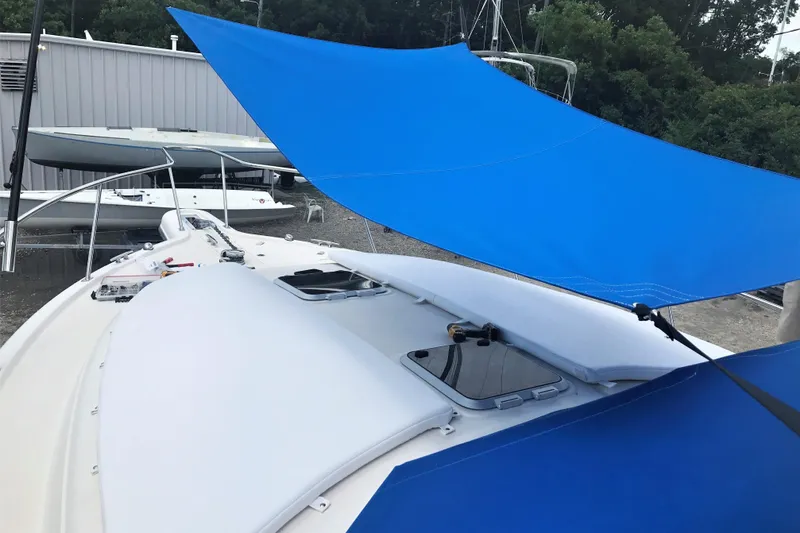  Yacht Photos Pics 2013 Pursuit OS 385 Offshore boat with blue sunshade, docked outdoors.
