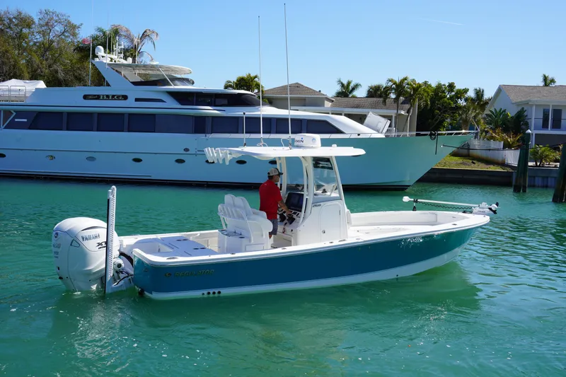  Yacht Photos Pics 2024 Regulator 26XO boat on turquoise water, with a large yacht in the background.