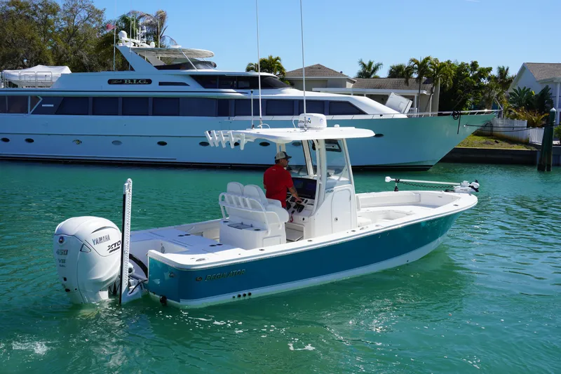  Yacht Photos Pics 2024 Regulator 26XO boat cruising in a marina with a luxury yacht in the background.