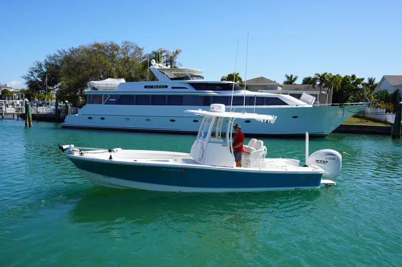  Yacht Photos Pics 2024 Regulator 26XO boat on clear water, with a yacht in the background.