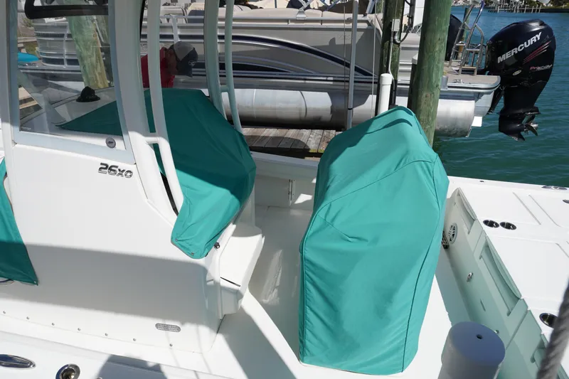  Yacht Photos Pics 2024 Regulator 26XO boat with teal seat covers docked by the water.