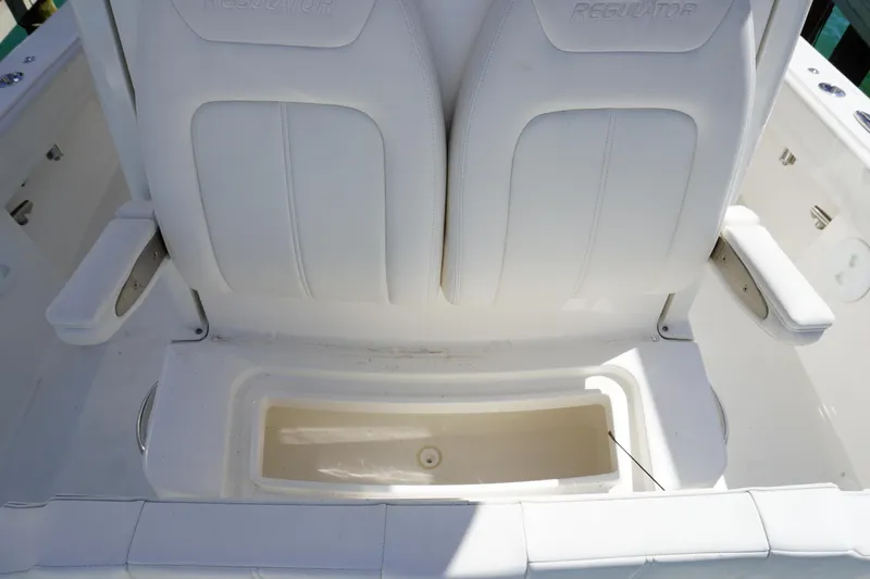  Yacht Photos Pics 2024 Regulator 26XO boat seating with storage compartment, featuring white cushioned seats.