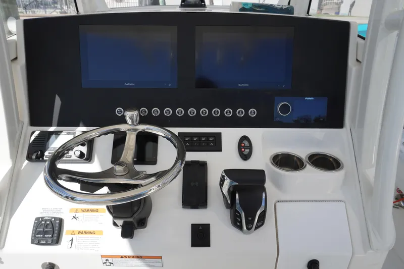  Yacht Photos Pics 2024 Regulator 26XO boat dashboard with dual screens and steering wheel.