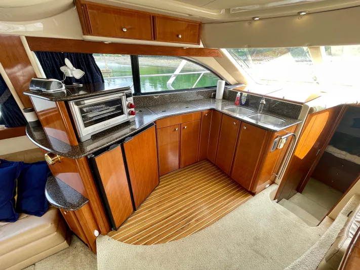 Remembrance Yacht Photos Pics Luxurious kitchen interior of 2006 Meridian 411 Sedan yacht with wood cabinetry and modern appliances.