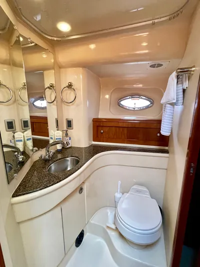 Remembrance Yacht Photos Pics Luxurious bathroom in 2006 Meridian 411 Sedan yacht with sink, toilet, and porthole window.
