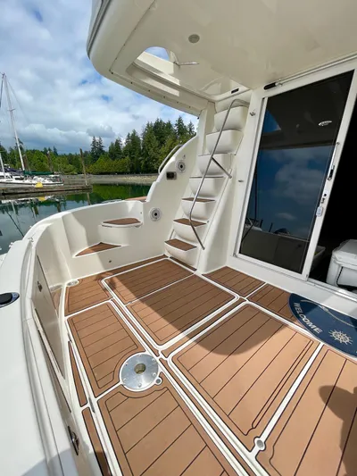 Remembrance Yacht Photos Pics 2006 Meridian 411 Sedan yacht deck with wooden flooring and ladder, docked by a serene marina.