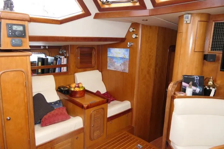 Majestic Yacht Photos Pics Luxurious 2006 Tayana 58 Deck Salon interior with wood finish and comfortable seating.