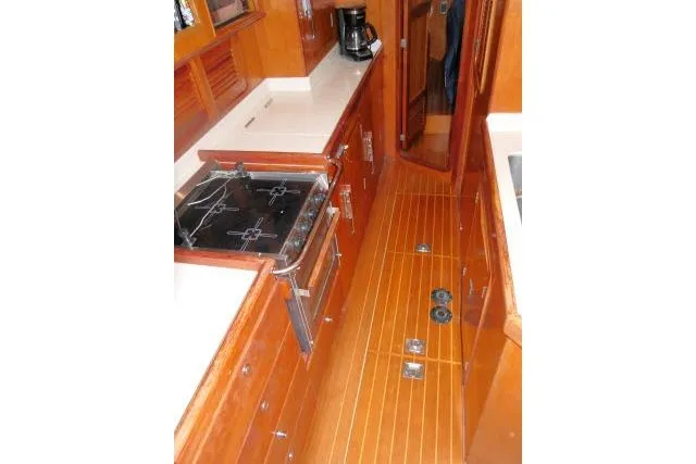 Majestic Yacht Photos Pics Galley kitchen in 2006 Tayana 58 Deck Salon yacht with wood finish and stove.
