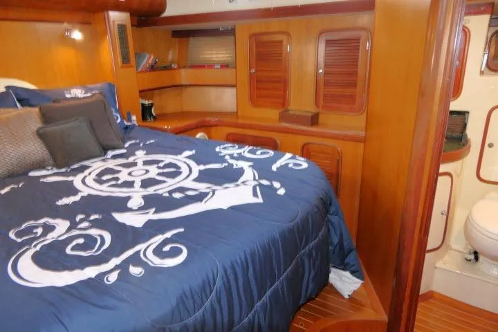 Majestic Yacht Photos Pics Luxurious 2006 Tayana 58 Deck Salon interior with nautical-themed bedding and wooden cabinetry.