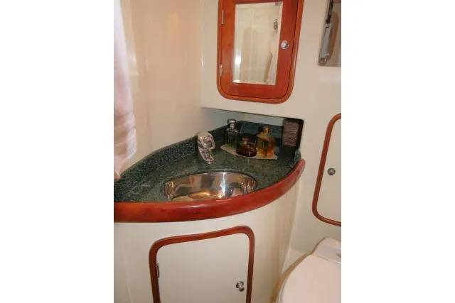 Majestic Yacht Photos Pics Bathroom sink area in 2006 Tayana 58 Deck Salon yacht, featuring wood accents and storage.