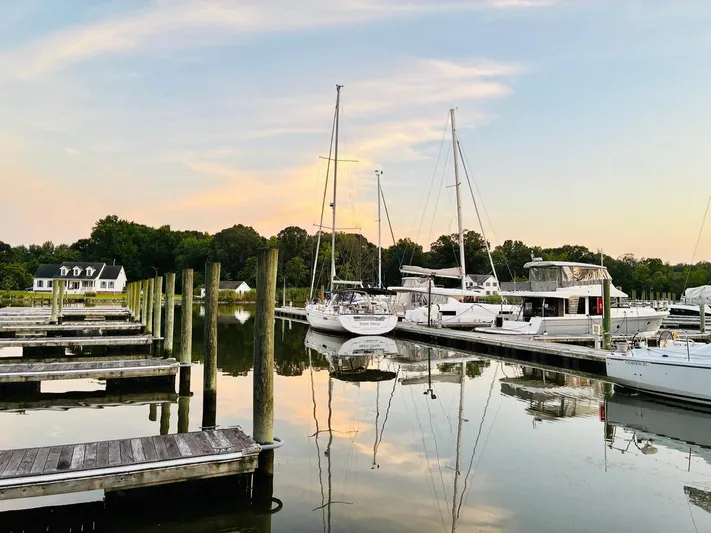  Yacht Photos Pics Beneteau Oceanis 45 sailboat docked at serene marina, 2017 model, during sunset.