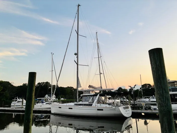  Yacht Photos Pics 2017 Beneteau Oceanis 45 sailboat docked at sunset, reflecting on calm water.