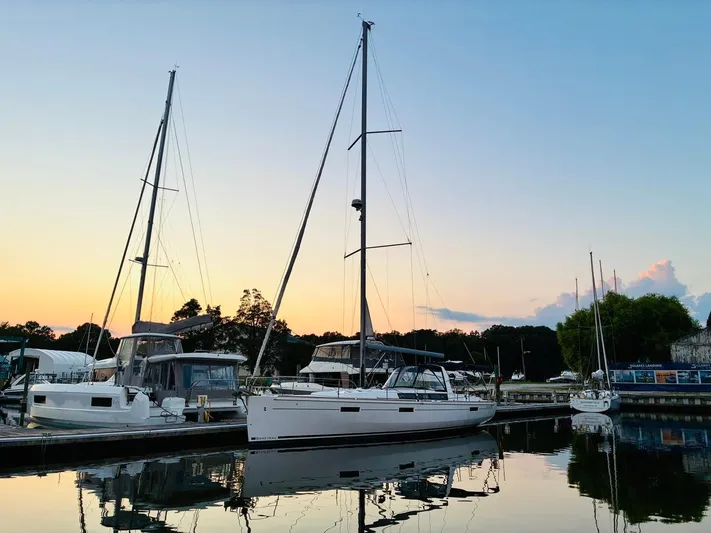  Yacht Photos Pics 2017 Beneteau Oceanis 45 sailboat docked at sunset, reflecting on calm water.