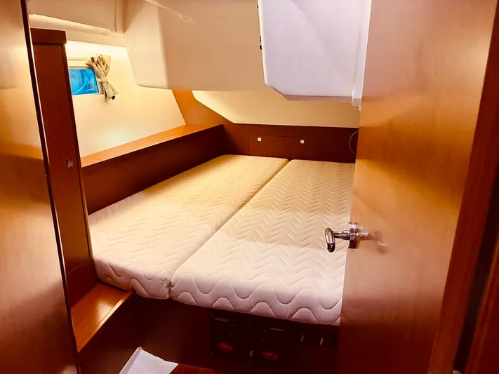  Yacht Photos Pics Cozy cabin interior of 2017 Beneteau Oceanis 45 sailboat with twin beds and wooden finish.