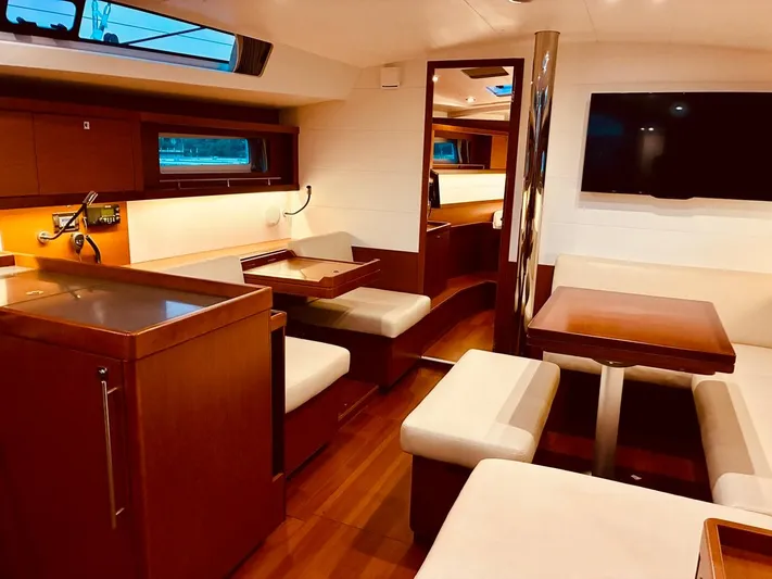  Yacht Photos Pics Interior of a 2017 Beneteau Oceanis 45 yacht with elegant wood finish and seating area.