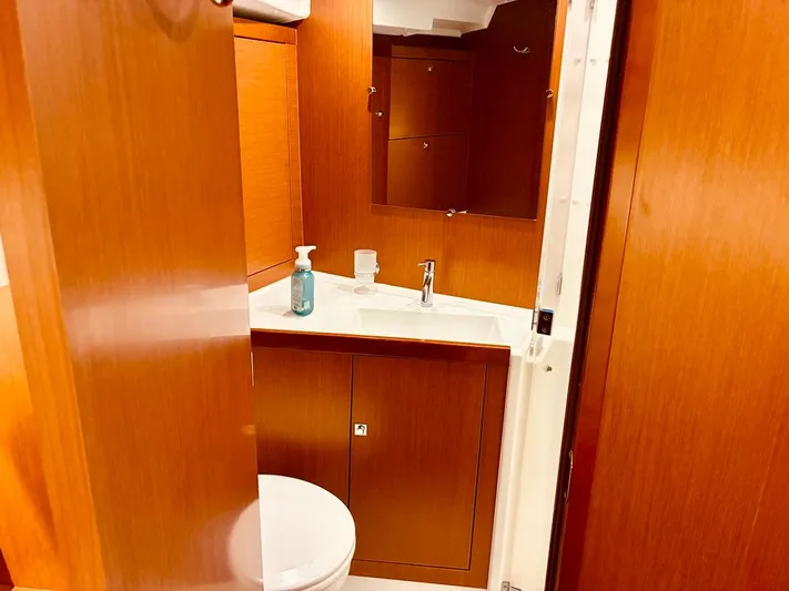 Yacht Photos Pics Interior of 2017 Beneteau Oceanis 45 yacht bathroom with wooden cabinetry and sink.