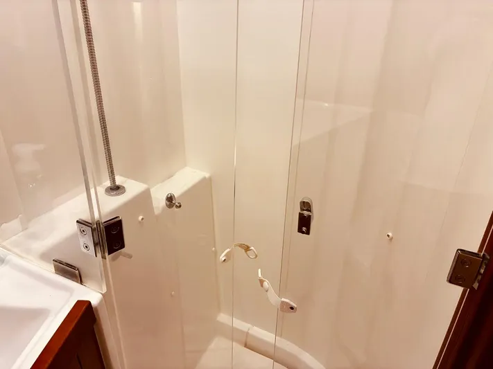  Yacht Photos Pics Shower area in 2017 Beneteau Oceanis 45 yacht, featuring glass doors and modern fixtures.