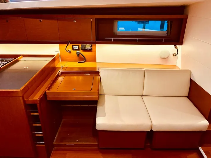 Yacht Photos Pics Interior of 2017 Beneteau Oceanis 45 yacht with wooden cabinetry and white seating.