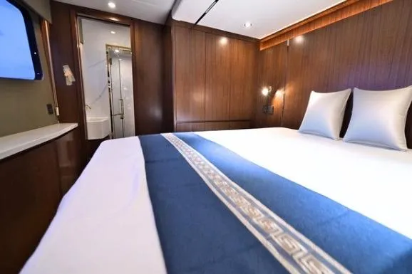 Evita Yacht Photos Pics Luxurious cabin interior of 2025 Custom NAUTICKS 62 yacht with elegant bedding.