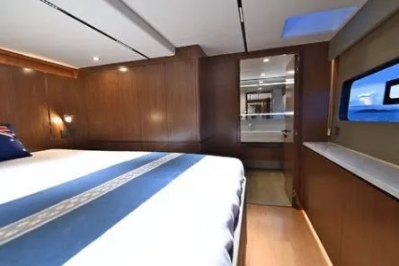 Evita Yacht Photos Pics Luxurious cabin interior of 2025 Custom NAUTICKS 62 yacht with wood paneling and ocean view.